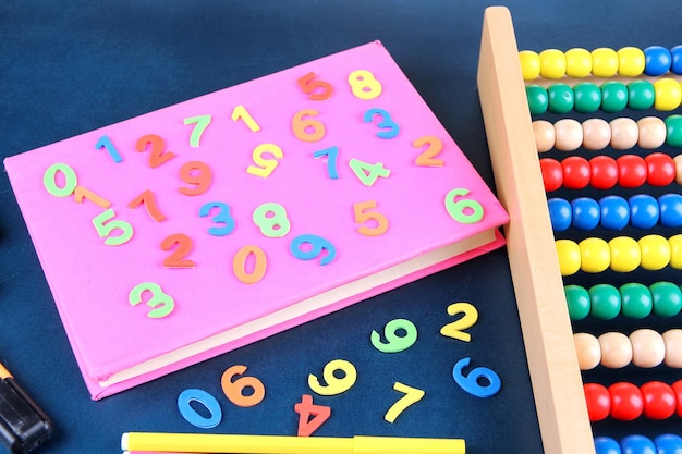 Colorful numbers abacus books and markers on school desk background