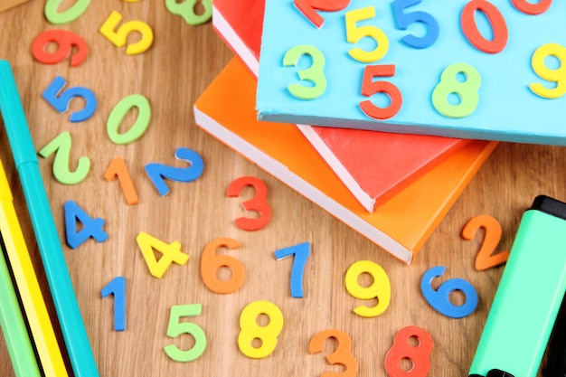 Photo colorful numbers books and markers on wooden background