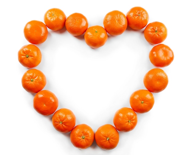 Colorful orange tangerines positioned in a heart shape on a white background top view