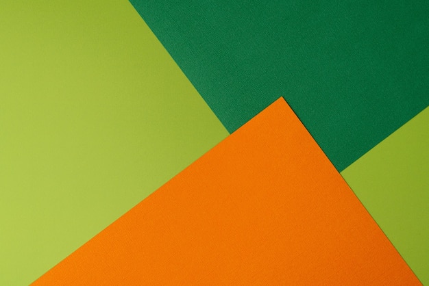 Colorful overlapped orange and green cardboard layers of paper on background top view