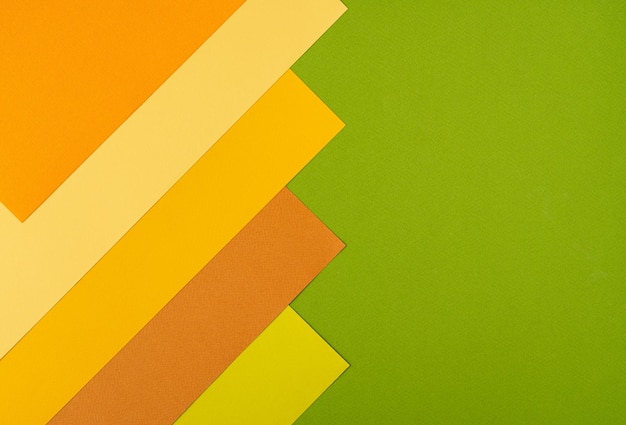 Colorful overlapped orange yellow and green cardboard layers of paper on background