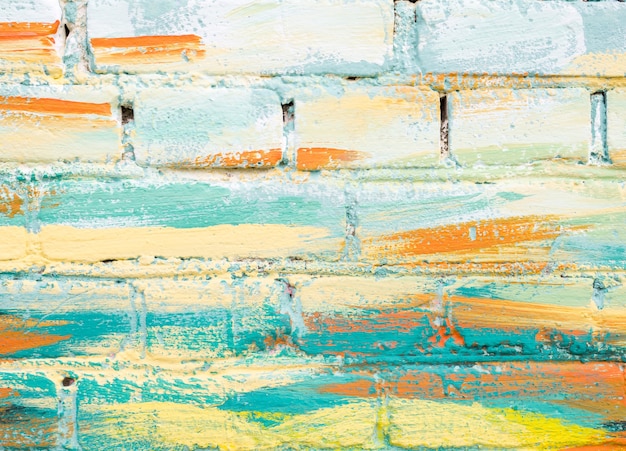 Colorful paint marks on a brick wall. Abstract painting colorful background texture. Pastel color. Mosaic of bricks in modern style. Painted rock texture. Facade of building. Masonry rough surface.