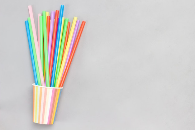 Colorful paper cups and colorful plastic straws for drinks