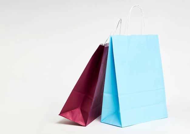 Colorful paper shopping bags on white background with copy space.