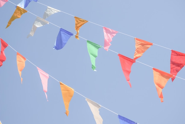 Colorful Party flags bunting hanging on blue sky for holiday decoration