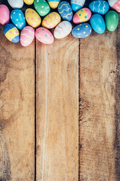 Colorful pastel easter eggs on wooden background with space. Vintage toned.