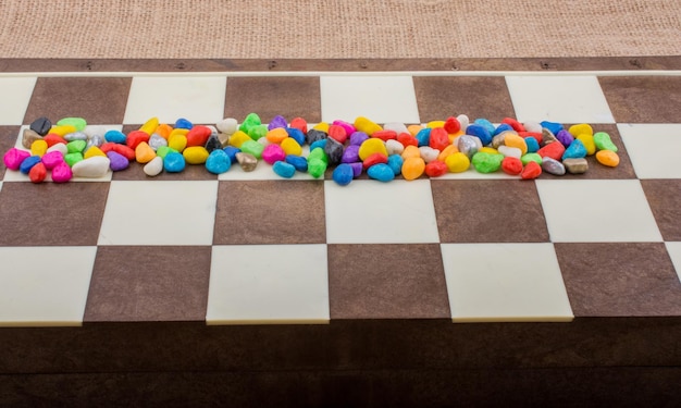 Colorful pebbles spread on checked board background