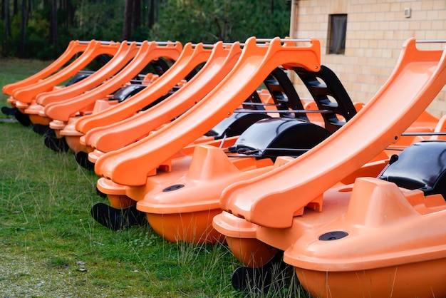 Colorful pedalos boat on green lake coast for rent