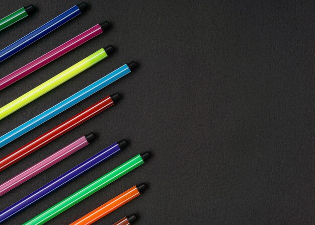 colorful pen on black background. Flat lay. Copy space.