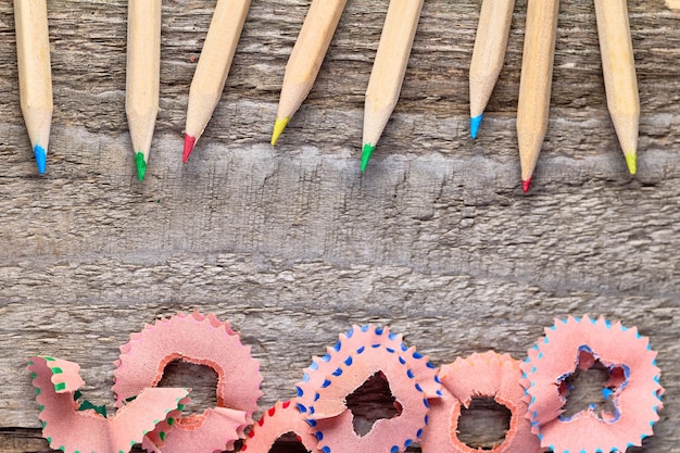 Colorful pencils and sharpen shavings on a wooden table