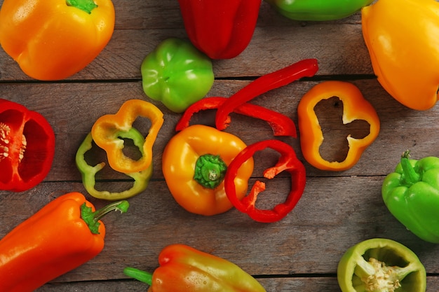 Colorful peppers on rustic wooden table, top view