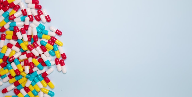 Colorful pills and capsules on blue background. Minimal medical concept. Pharmaceutical, Medicine.