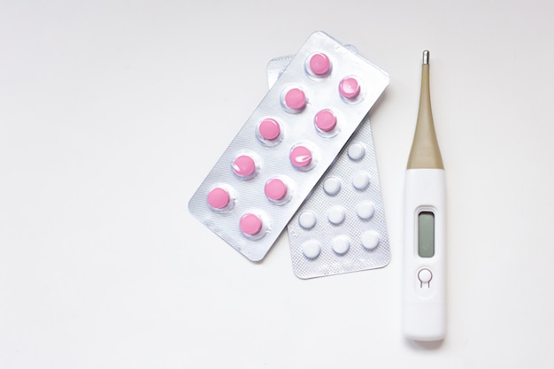 Colorful pills, capsules, tablets and thermometer.