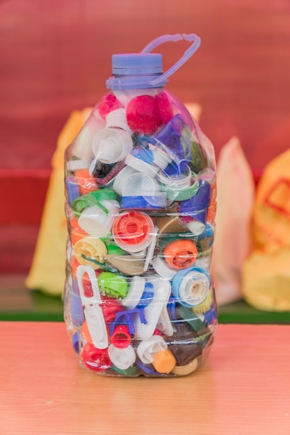 colorful plastic bottle caps ready for recycling in transparent plastic bottle