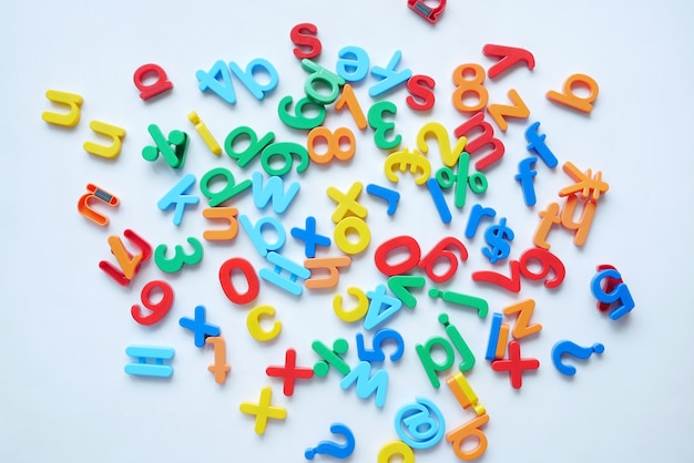 Colorful plastic letters on white background top view