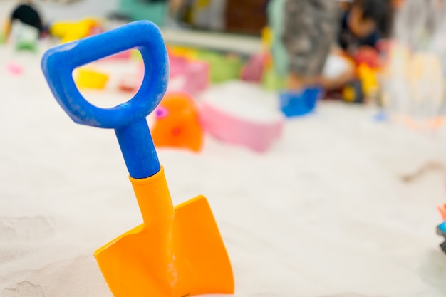 Colorful plastic shovel for children in sandbox playground.