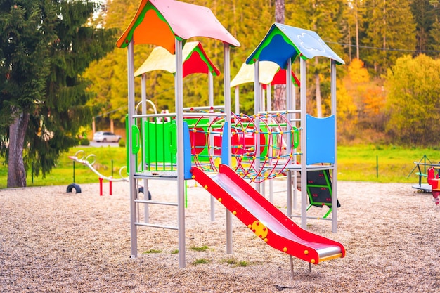 Colorful playground on yard in the park Colorful children playground activities in public park surrounded by green trees