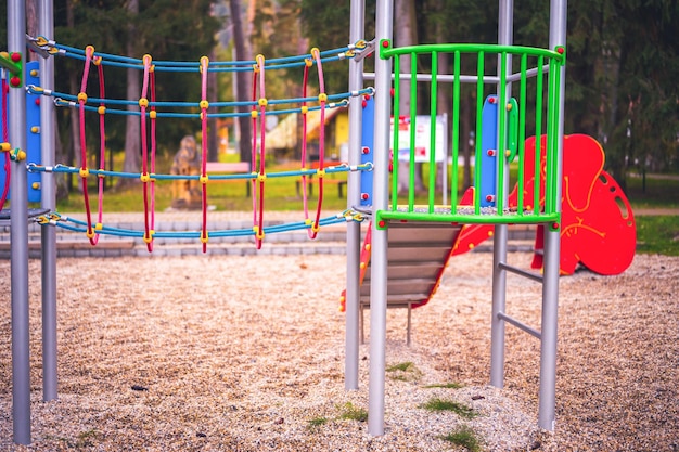 Colorful playground on yard in the park Colorful children playground activities in public park surrounded by green trees