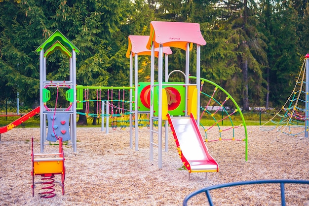 Colorful playground on yard in the park Colorful children playground activities in public park surrounded by green trees