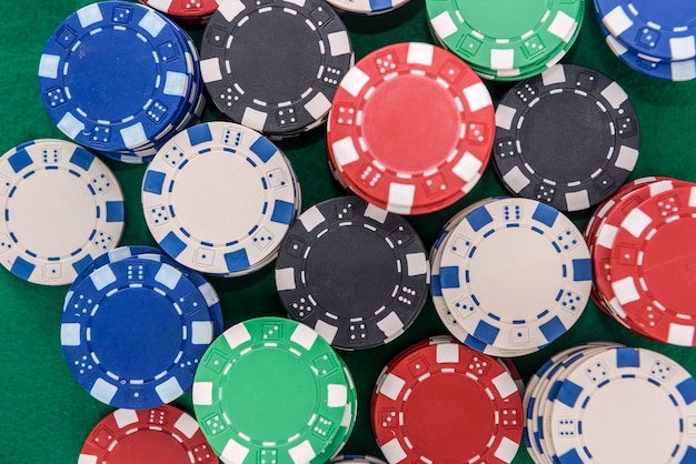 Colorful poker chips on green table