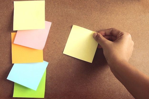 colorful post it paste on brown wood board have copy space 