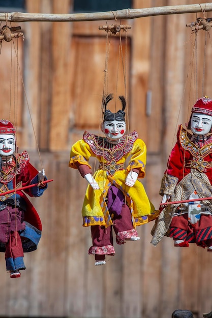 Colorful puppets in a tourist stall on the street market in Burma Myanmar Handmade dolls hanging on display store