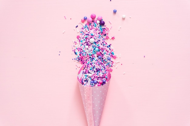 Colorful purple sprinkle blend on a pink background.