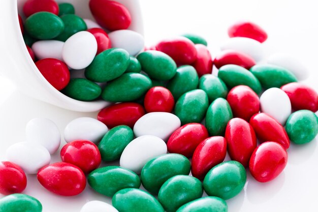 Photo colorful red, green and white candies on white background.