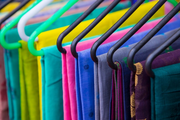 Colorful Saree clothes on hangers in a shop Selective focus