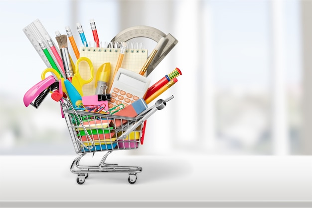 Colorful school supplies in shopping cart