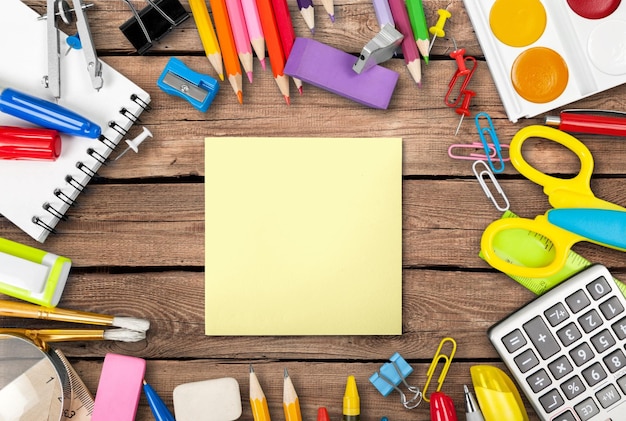 Colorful school supplies on wooden background