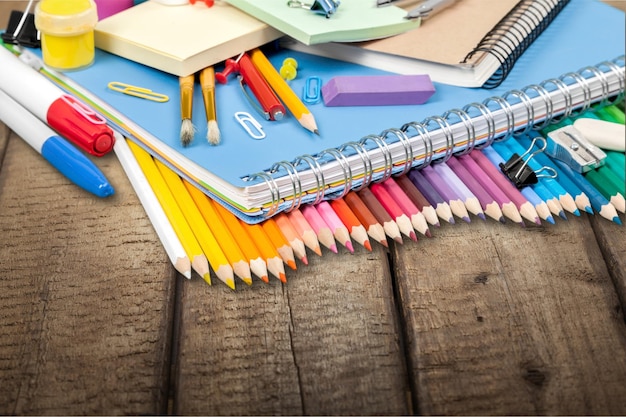 Colorful school supplies on wooden background