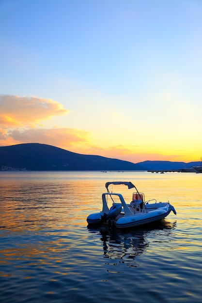 Colorful seascape with boat at sundown