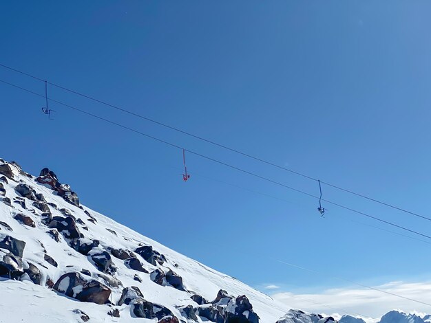 Colorful seats of skiing lift in the mountains on a blue sky background transportation to the top