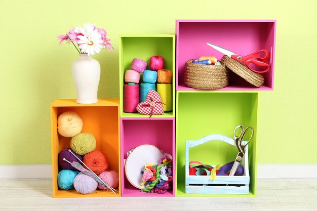 Colorful shelves of different colors with utensils on wall background