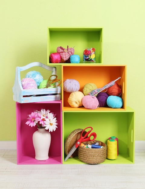 Colorful shelves of different colors with utensils on wall background