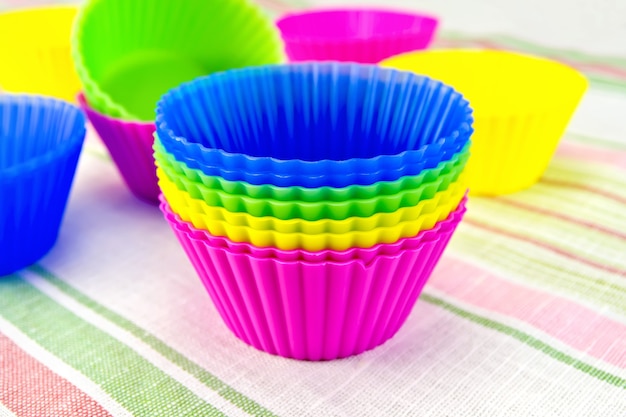 Colorful silicone molds for cupcakes on linen