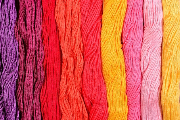 Colorful skeins of floss as background texture close up