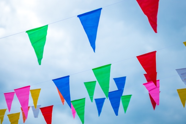 Colorful small flags paper made hanging on the rope with blue sky background