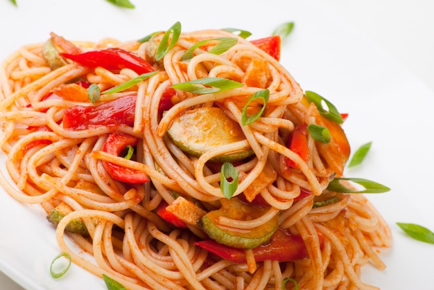 Colorful spaghetti with zucchini and tomato and grated cheese