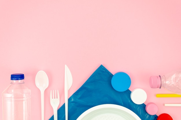 Colorful spoons and dish on pink background