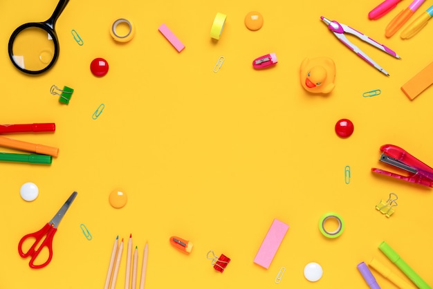 Colorful stationery on yellow surface