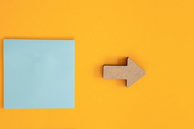 Colorful sticky notes and different wooden arrows on yellow background