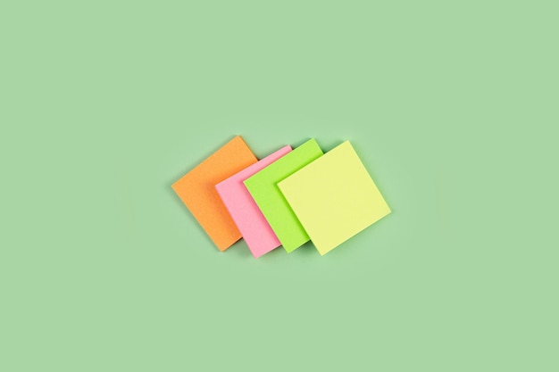 Colorful sticky notes on green background four colored notes on an isolated green background