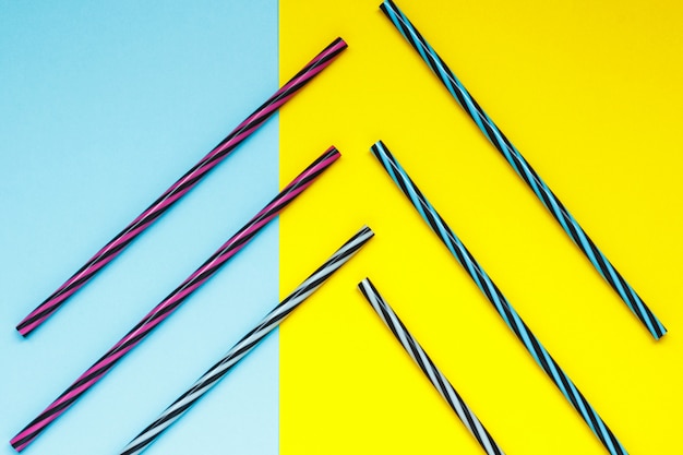 Colorful striped straw on a blue and yellow background