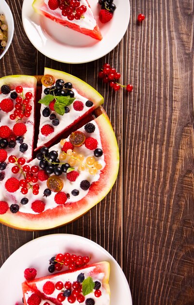 Colorful summer watermelon piece of cake with whipped cream and berries Refreshment summer dessert food