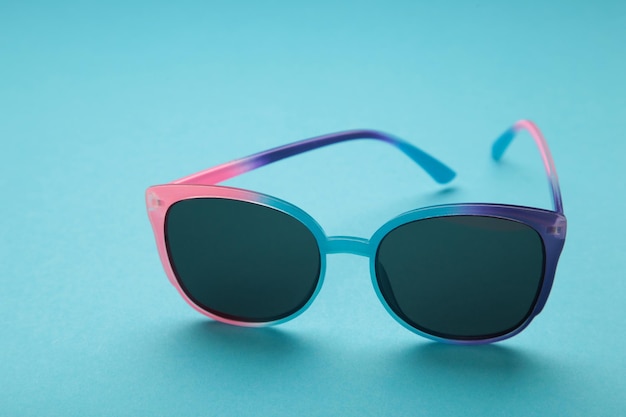 Colorful sunglasses on blue background Top view