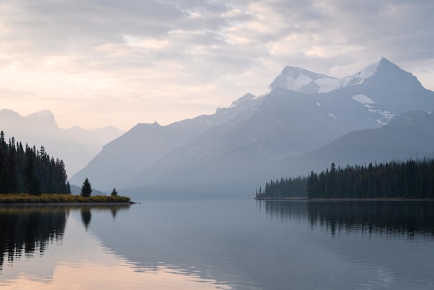 Colorful sunrise on the bank of still alpine lake with prominent mountain Jasper NP Canada