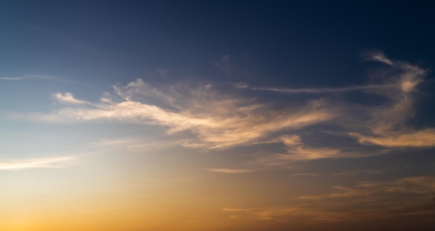 Colorful sunset sky in the evening with orange sunlight clouds on dark blue