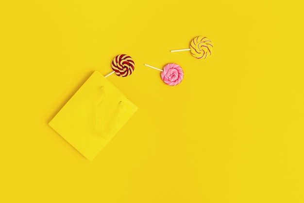 Colorful sweets candy lollypop out of yellow paper bag Unhealthy food concept Refusal of sweet